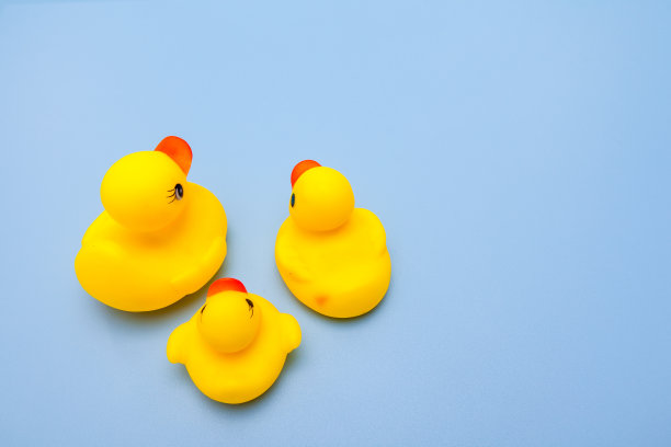 蓝色背景上的黄色鸭子家族的玩具图片下载