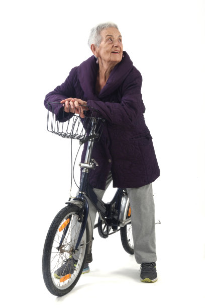 一位年长的女士在白色背景下摆着一辆自行车图片下载