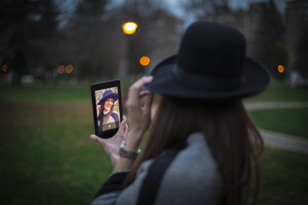 戴着帽子的女人用平板电脑自拍图片下载