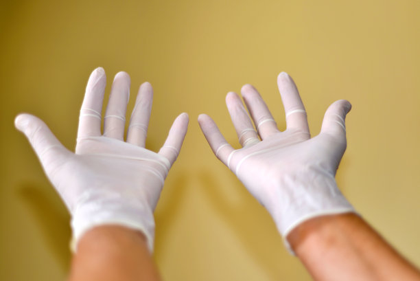双手在乳胶手套上隔离白色图片下载