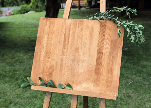 带板的木制画架。在黑板上写着白色的油漆-欢迎图片下载