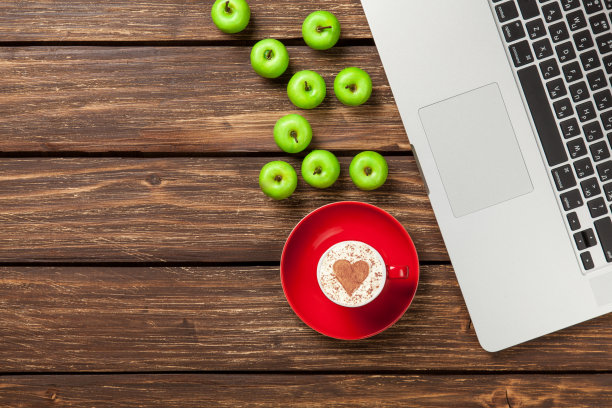 心形的卡布奇诺，笔记本旁边放着苹果图片下载