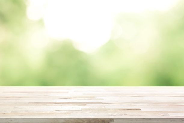 木制桌面上模糊抽象的自然绿色背景素材图片