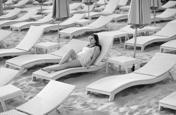 黑白照片性感的女人在衣服躺在日光浴床上图片下载