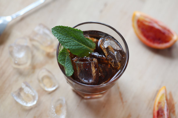 鸡尾酒威士忌可乐加冰在玻璃杯中。木板上放着水果的碎片。从以上观点。照片景深。图片下载