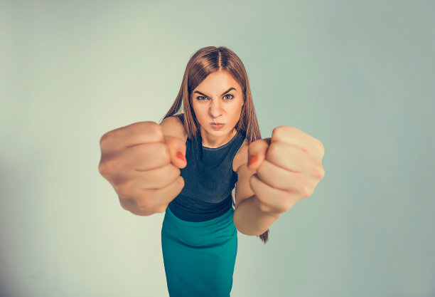 特写肖像愤怒的年轻女子显示拳头即将打人或有神经原子崩溃孤立的黑色背景。人类的消极情绪，面部表情，感情，态度图片下载