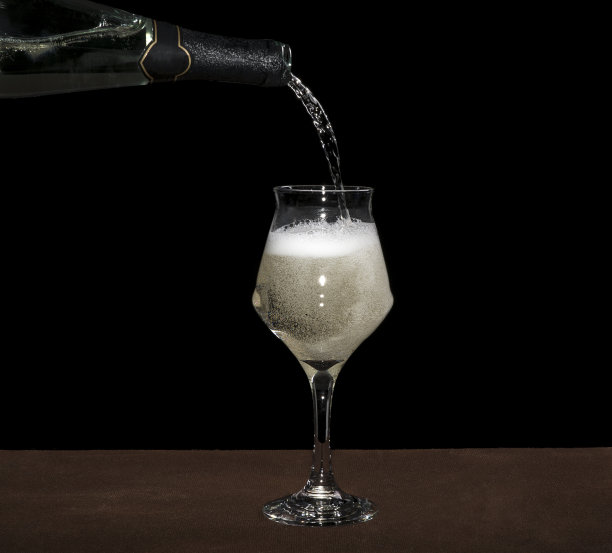 白葡萄酒瓶倒葡萄酒杯在黑色背景图片下载
