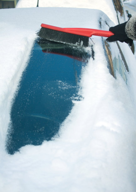 一个女人正在刷车里的雪图片下载
