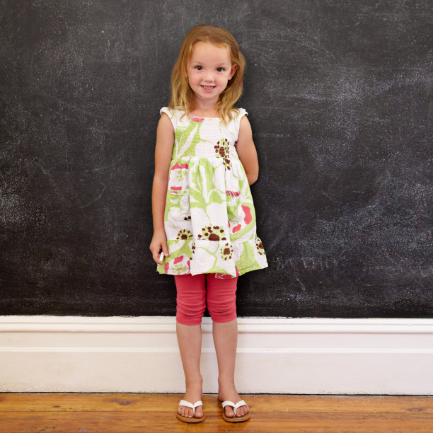 漂亮的小女孩站在家里的黑板前图片下载