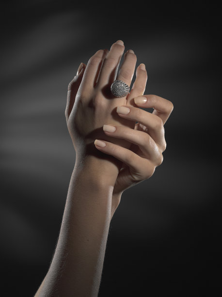 戴戒指的手放在黑色背景上图片下载