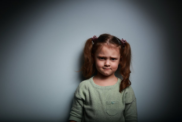 悲伤愤怒的孩子看着黑暗的背景和阴影图片下载