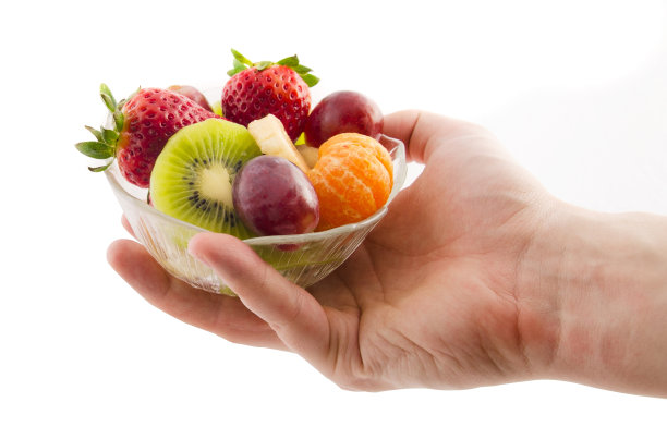 手捧盛着新鲜水果的玻璃碗图片下载