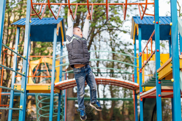 小男孩在操场上玩，背景是模糊的公园图片下载