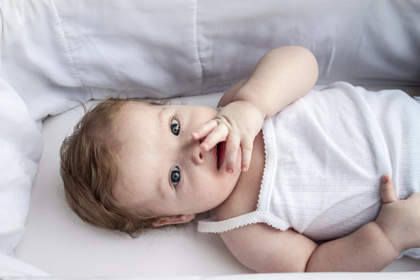 快乐的婴儿，拇指在他的嘴里图片下载