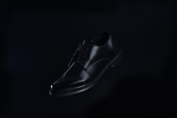黑色皮鞋的男性黑色背景和深色调。图片下载