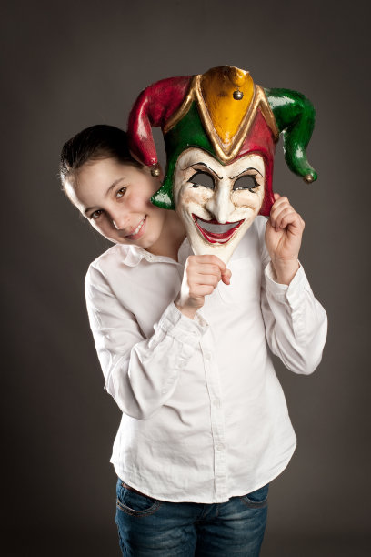 年轻的女孩拿着狂欢面具图片下载