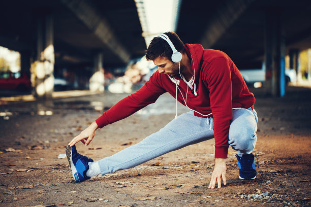 年轻的健身运动员在跑步前伸展双腿图片下载