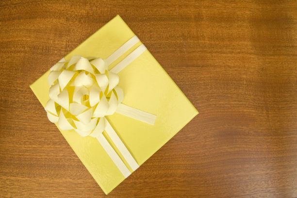 黄色礼品盒放在木桌上图片下载