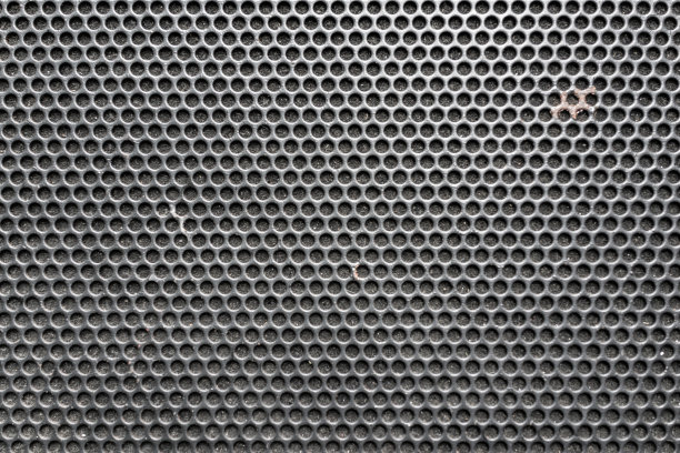 音乐喇叭前的金属蜂窝格栅图案作为背景图片下载