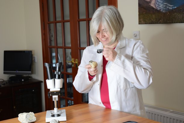 女科学家对着一块岩石微笑图片下载