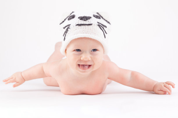 可爱快乐的小男孩穿着尿布和白色的猫帽子图片下载