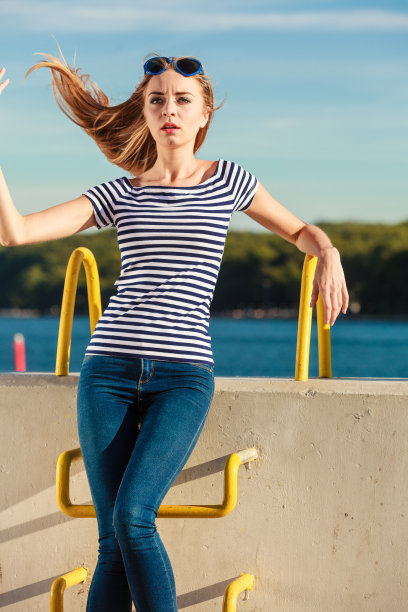 女人休闲风格倚着石墙图片下载