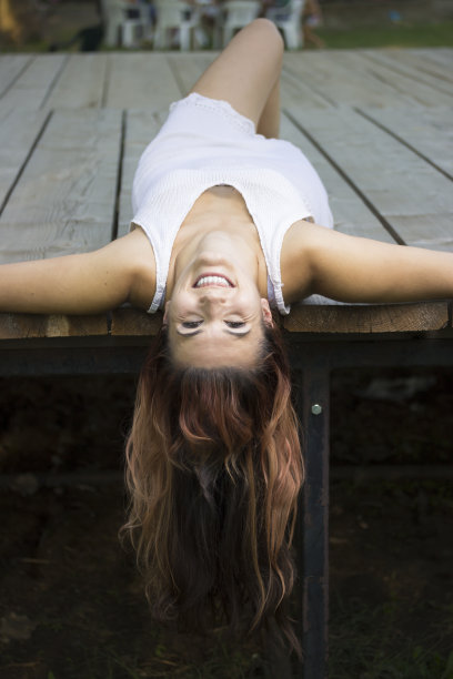 快乐美丽的女孩躺在木板上。图片下载