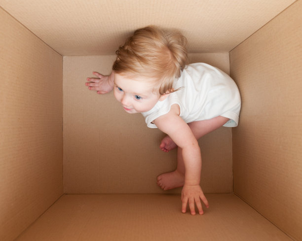 小孩在箱子里玩。图片下载