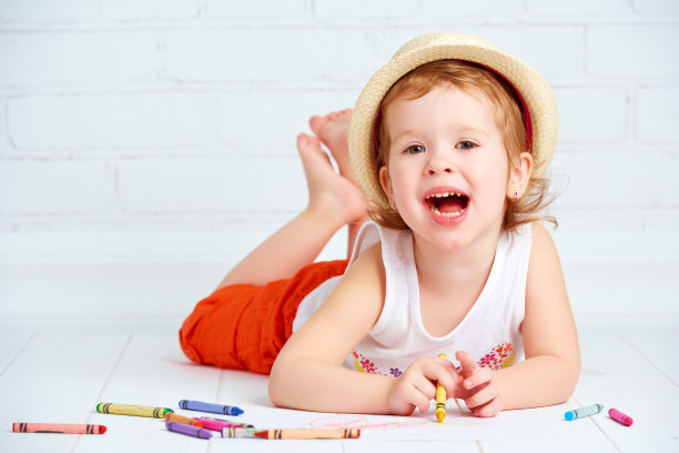 快乐的小艺术家女孩戴着帽子画铅笔图片下载