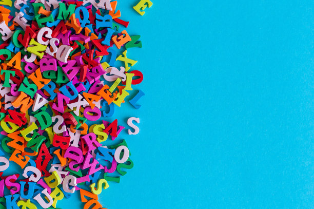 英文字母表的彩色字母排列在蓝色的背景与空白。教育或经营理念图片下载