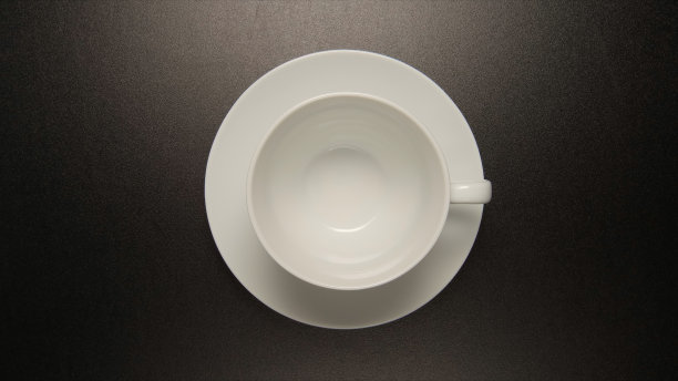 顶视图:黑色桌子上的白色咖啡杯图片下载