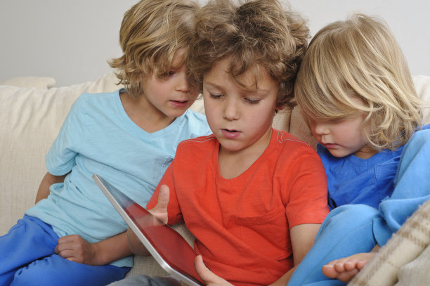 三个小男孩在玩触屏平板电脑图片下载