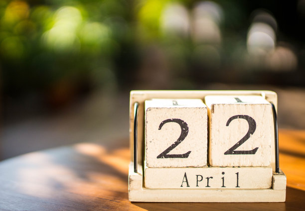 木桌上的木历显示了4月22日，以自然为背景的地球日素材图片