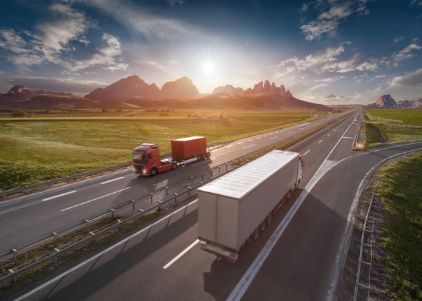 两辆孤独的卡车在田园诗般的阳光明媚的早晨行驶在高速公路上图片下载