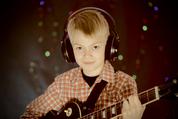 少年戴着耳机和吉他听音乐图片下载