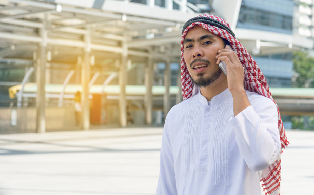 在城市里用手机发信息的阿拉伯商人图片下载