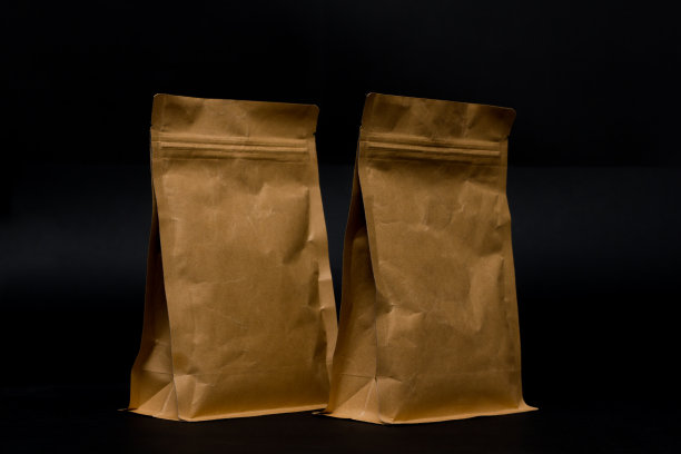 两个纸袋孤立在黑色背景上。图片下载