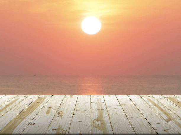 木头桌面上的阳光模糊的背景。图片下载