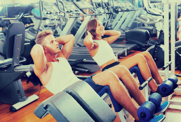 男人和女人在健身房做腹肌运动图片下载