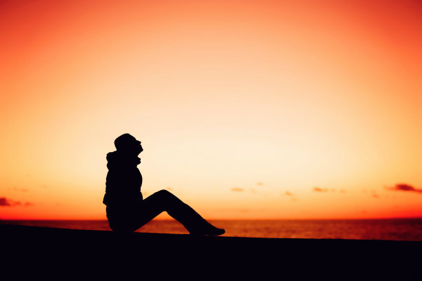 一个女人的剪影坐在美丽的边沿图片下载