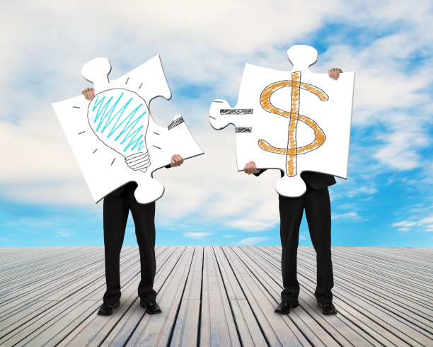 两个商人正在为“金钱创意”拼装拼图图片下载