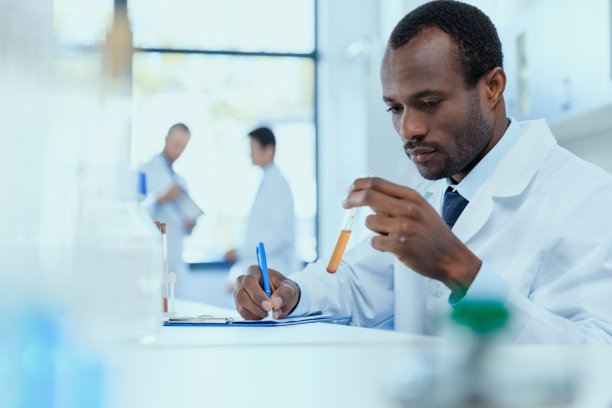 穿白大褂的非裔美国科学家拿着试管做实验研究素材图片