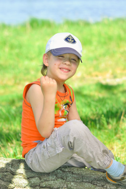 男孩坐在一根原木上图片下载