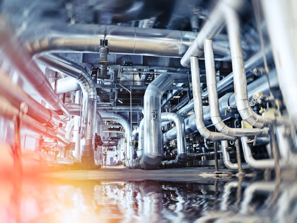 工业工厂。各种机械装置和金属管。健美的形象。动态模糊效果。图片下载