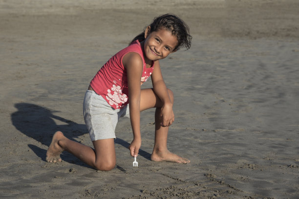 可爱的拉丁女孩在沙滩上玩耍图片下载