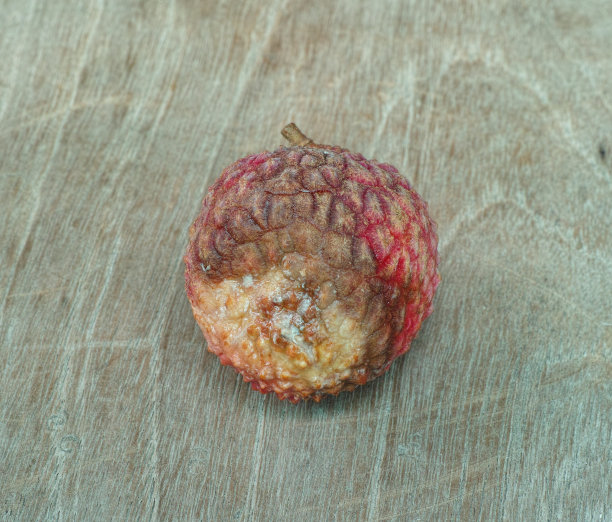 木桌上有腐烂的荔枝果图片下载