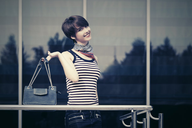 快乐年轻的时尚女人与手提包旁边的购物中心的窗口图片下载