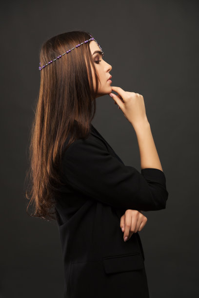 黑色背景下穿着黑色夹克的悲伤年轻时尚模特图片下载