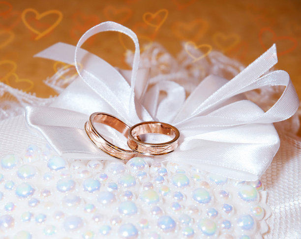 针垫上有金婚戒。背景与心图片下载