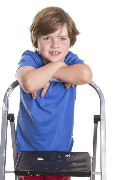 一个小男孩靠在梯子上。图片下载